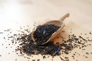 Black tea Earl Grey Ceylon Darjeeling on wooden shovel scoop closeup