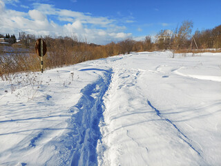 Fototapeta na wymiar Winter path through the park among snowdrifts. Mobile Photo