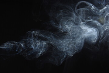 Abstract wisps of smoke on a black background.