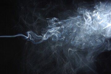 Abstract wisps of smoke on a black background.