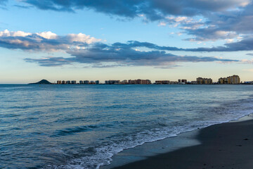 seashore of La Manga del Mar Menor with its many hotels and beaches at sunset under an expressive...