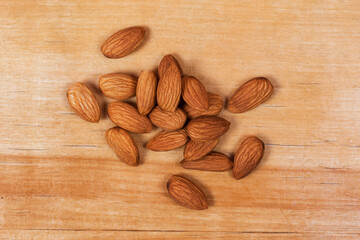 Pile of almond nuts lying on wooden table background