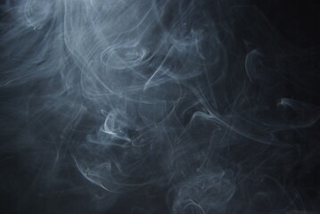 Abstract wisps of smoke on a black background.