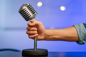 Close-up of a hand grasping an old vintage microphone