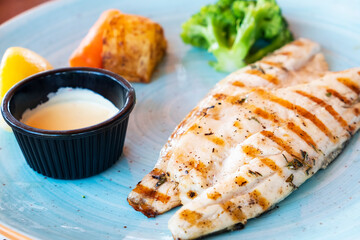 Grilled chicken breast with vegetables and sauce.
