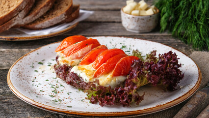 Baked meat under cheese and tomatoes.