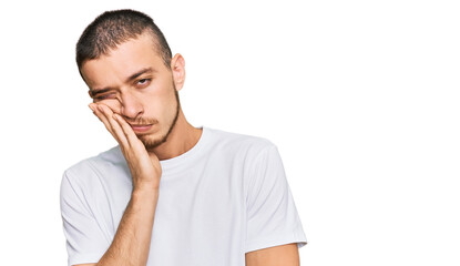 Hispanic young man wearing casual white t shirt thinking looking tired and bored with depression problems with crossed arms.