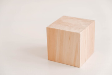 Wooden cube from natural wood on a white background. Copy, empty space for text