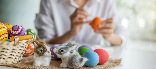 Easter eggs and Decoration on white desk with happy woman painting eggs background. Family preparing for Easter.