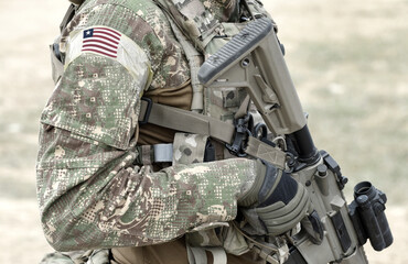 Soldier with assault rifle and flag of Liberia on military uniform. Collage.