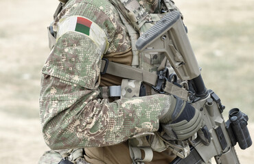 Soldier with assault rifle and flag of Madagascar on military uniform. Collage.