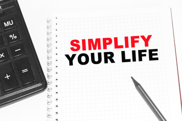 Text SIMPLIFY YOUR LIFE on paper card, Pencils on table - business, banking, finance and investment concept.