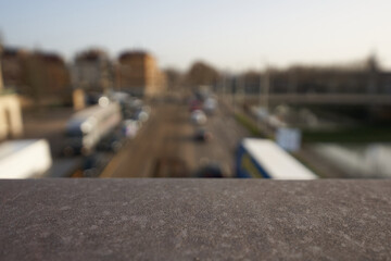 Gray railing. Traffic jam in the city with trucks and cars. Residential buildings and river. high perspective. Selective focus.
