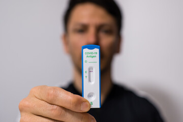 Mann / Tester mit negativem Corona Schnelltest / Selbsttest Ergebnis 