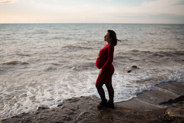 Stylish pregnant woman. Beautiful young pregnant woman enjoying the sunset. Pregnant tummy. The pleasure of pregnancy. Life style. Motherhood.Maternity.