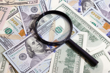 Magnifying glass on the background of bundle dollars - texture, background