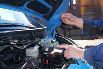 Checking the presence and level of oil in the car engine on the road by a master. The technician's...