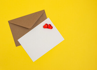 Greeting card mockup, white blank card with paper envelope and hearts on yellow background. Blank love letter, valentine's day, wedding invitation