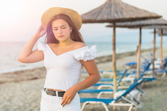 Portrait of teenage cheerful plus size teenage girl wearing hat enjoying the beach. smiling, happy, positive emotion, summer style.