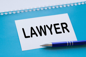 Written words LAWYER on paper notebook on BLUE background.