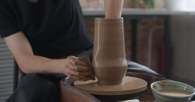Potter shapes a jug in slow motion on a potter's wheel, video from pottery workshop, potter makes ceramics in slow motion, 4k 60p Prores HQ 10 bit