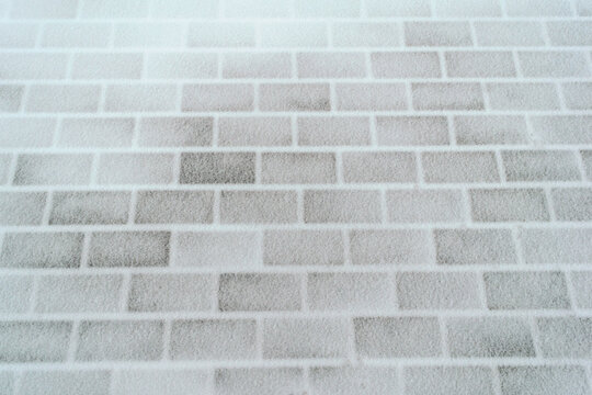 The paving slabs are covered with a thin layer of snow. Texture. Background.