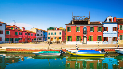 Burano island canal, colorful houses and boats in the Venice lagoon. Italy