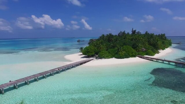Tropical island in Maldives, aerial view. Beautiful paradise island with white sand, coco palm trees and crystal clear turquoise water. Maldives, Seychelles, Bora Bora, French Polynesia.