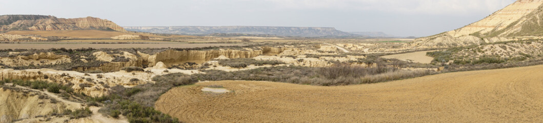 panorama view of the desert grasslands and mesas and table mountains in the Bardenas Reales desert in northern Spain
