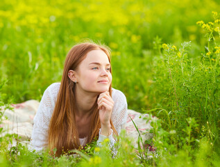 Redhead girl in a rapeseed field