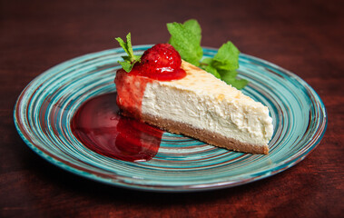 Slice of fresh delicious cheesecake with strawberry and leaf of mint