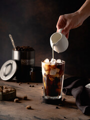 Cold coffee with cream on a dark background
