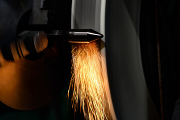 High-precision machining of the shaft with an abrasive stone with sparks on a cylindrical grinding machine.