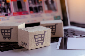 Online shopping. Credit card and cardboard box with a shopping cart logo on laptop keyboard. Shopping service on The online web. offers home delivery.
