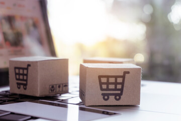 Online shopping. Credit card and cardboard box with a shopping cart logo on laptop keyboard. Shopping service on The online web. offers home delivery.