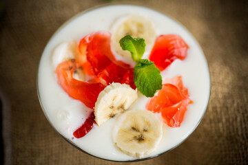 homemade sweet yogurt with bananas and pieces of fruit jelly