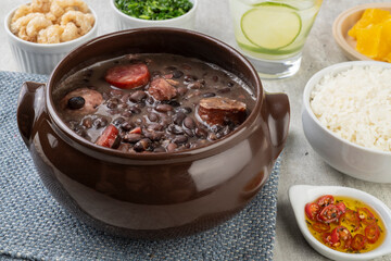 Traditional brazilian feijoada with rice, orange, kale, cracklings, pepper and caipirinha