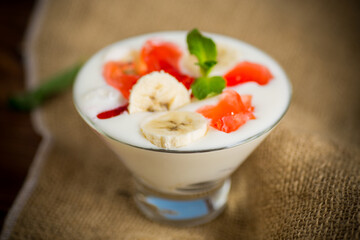homemade sweet yogurt with bananas and pieces of fruit jelly