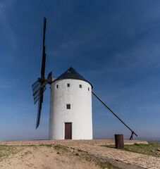 whitewashed historic windmill typical of the La Mancha region of central Spain under a blue sky