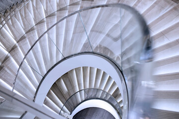 Fototapeta premium Spiral staircase in white marble with glass railing
