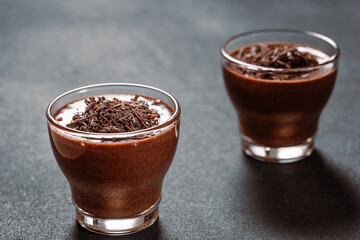 Homemade dark chocolate mousse in glasses on dark grey table