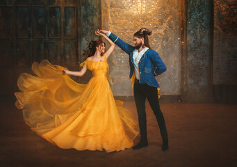 loving couple is dancing at fairy ball. Happy beauty woman fantasy princess in yellow dress and guy...