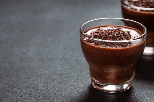 Homemade dark chocolate mousse in glasses on dark grey table