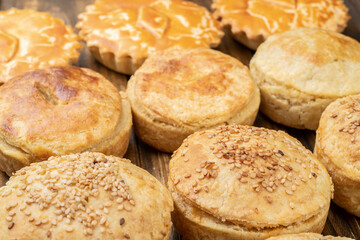 Assorted stuffed homemade pies over wooden table