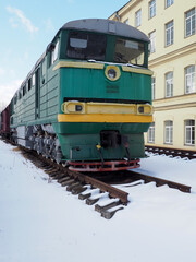 an old locomotive standing on a spare railway track in the winter