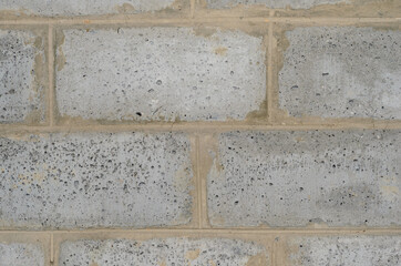 wall of large gray brick blocks with cement joints.