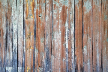 Texture of old painted wooden planks with peeling paint covered with cracks close-up.