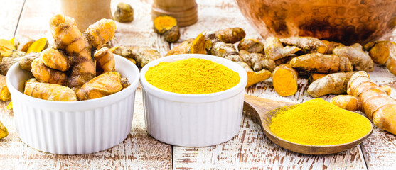 turmeric roots and turmeric powder, on a white table