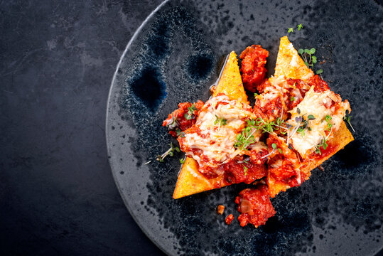 Modern Style traditionelle italienische Polenta alla Sarda con Salsiccia mit Rohwurst serviert als Draufsicht auf einem Nordic Design Teller mit Textfreiraum links 
