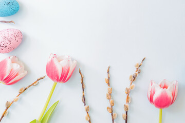 Flat lay easter composition with pink tulips and eggs on color background